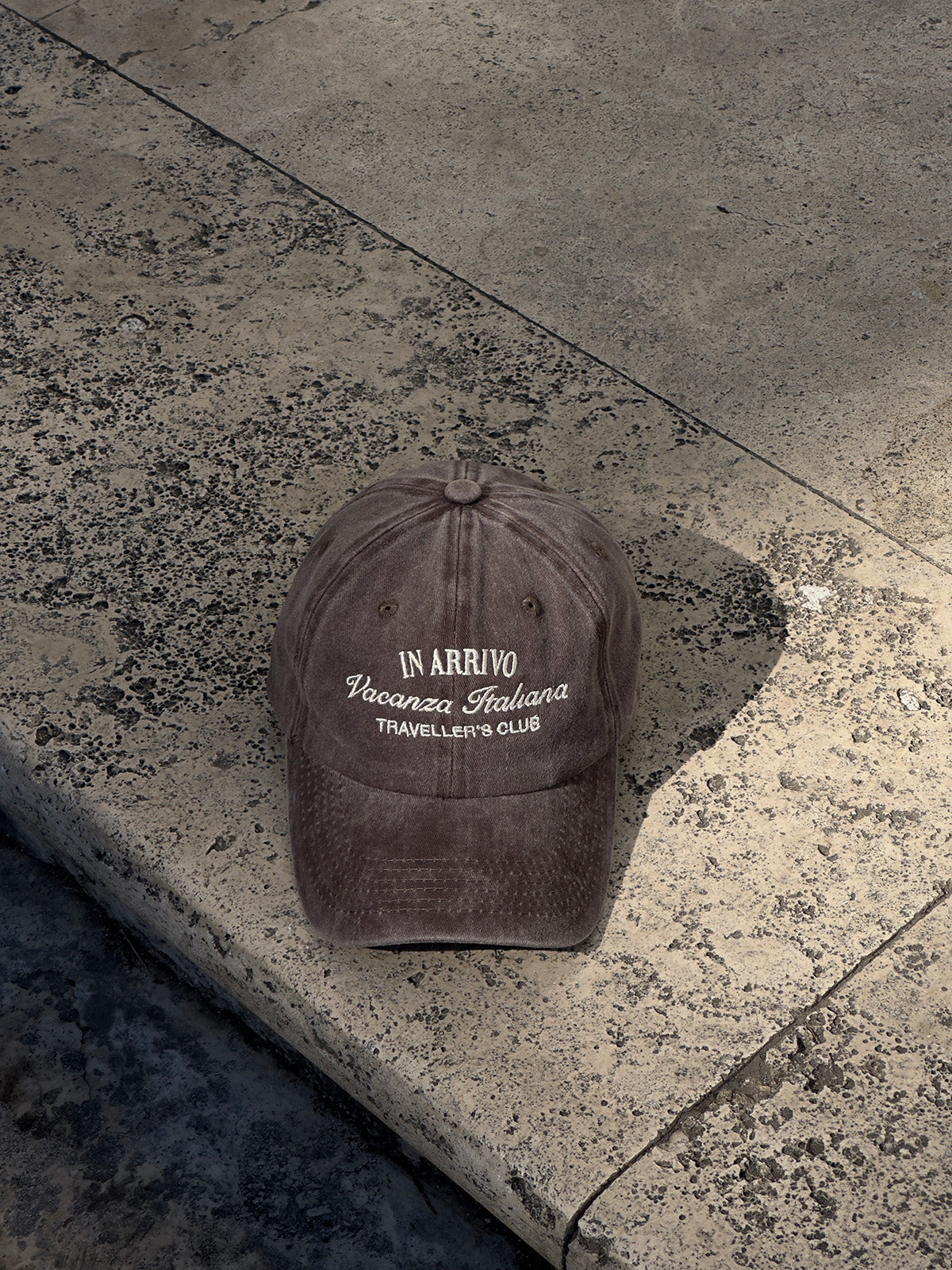 Brown cap with text on a stone surface in arrivo italian lifestyle brand