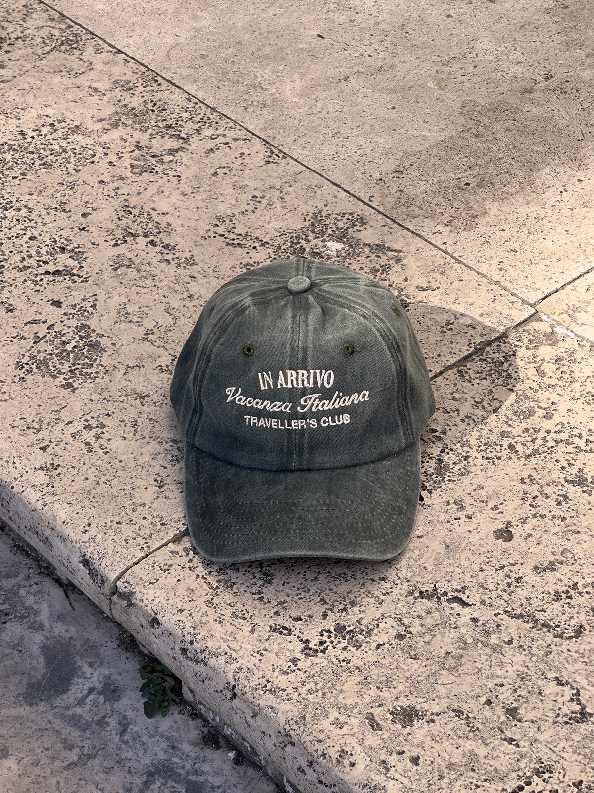 Green cap with text on a concrete surface in arrivo italian lifestyle brand